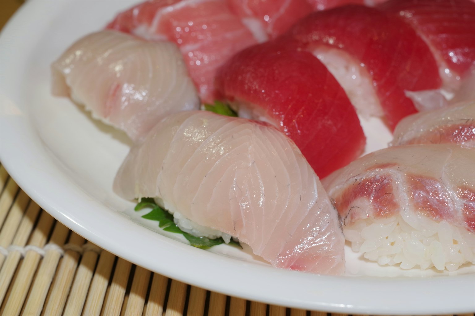 Piring sushi segar yang menampilkan ikan putih dan ikan merah