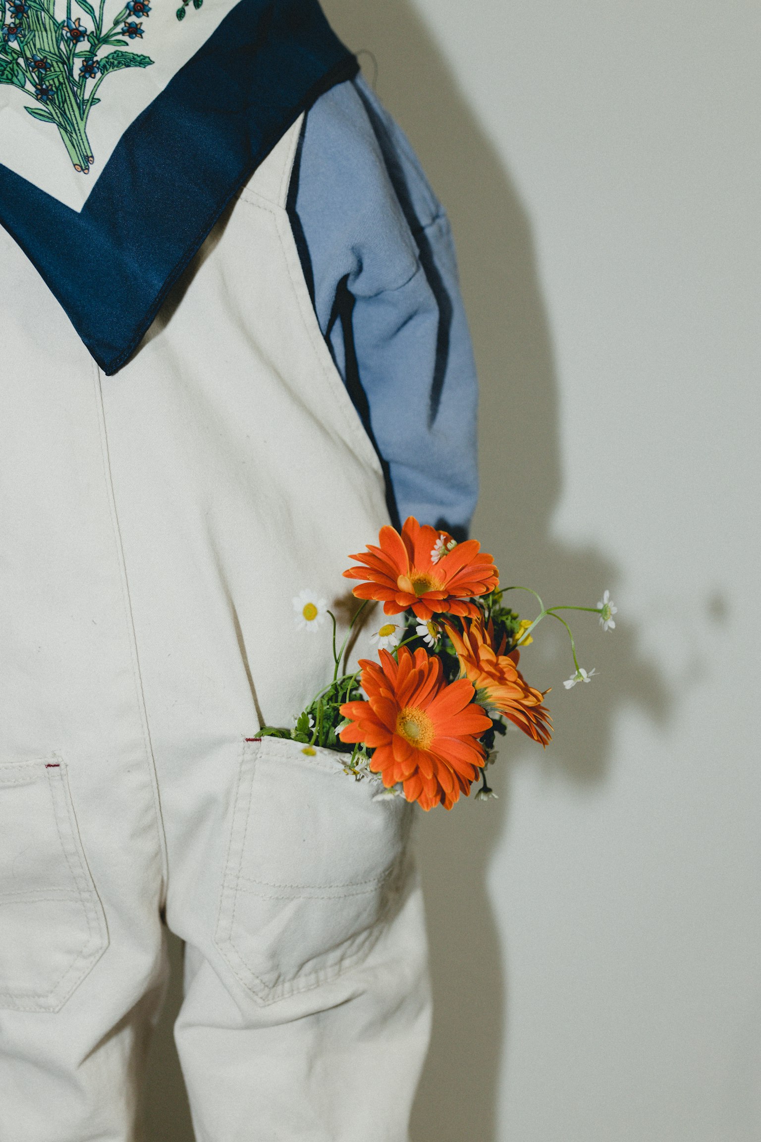 Personne en tenue blanche tenant des fleurs orange
