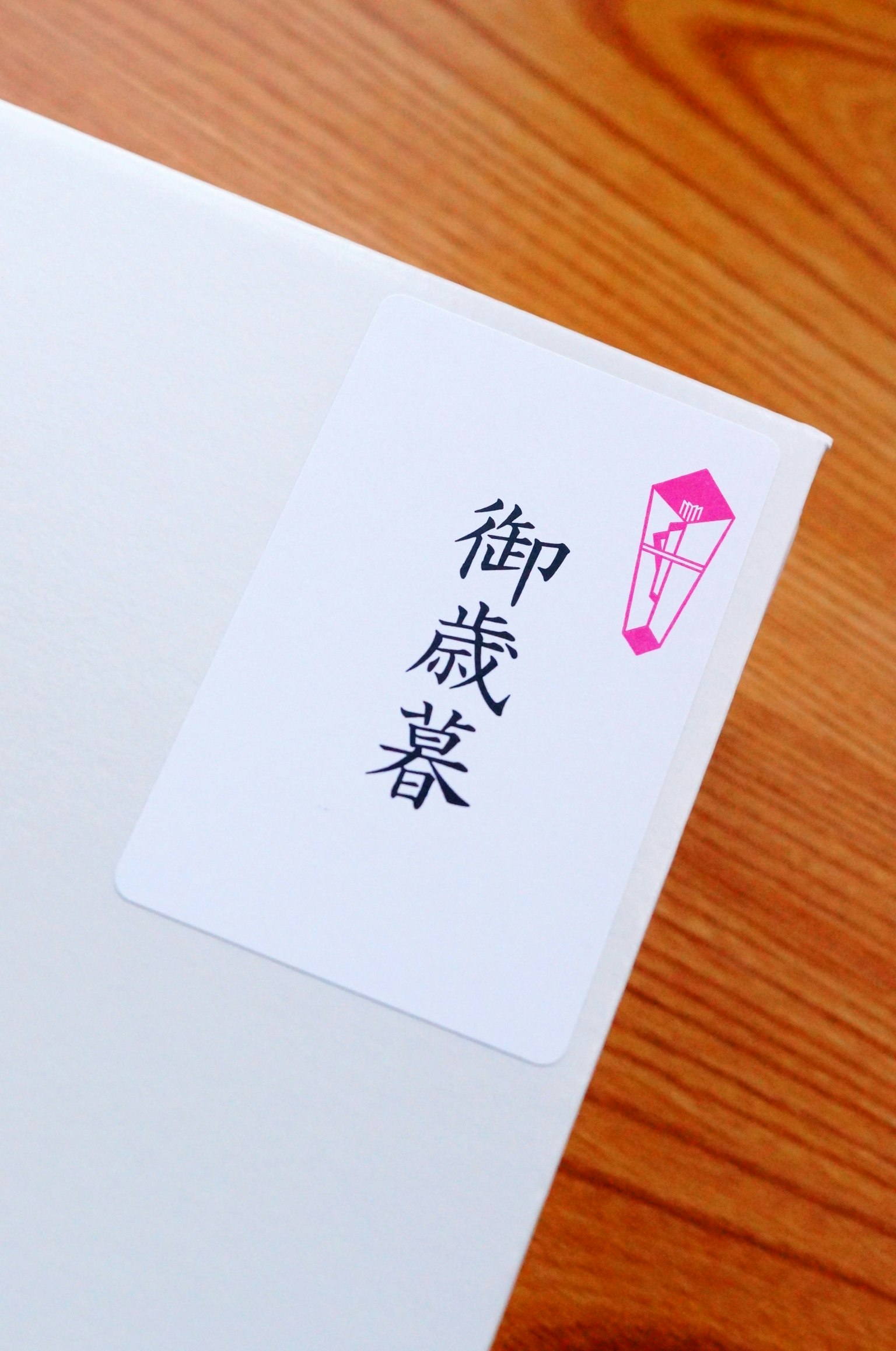 Enveloppe blanche avec une étiquette rose comportant du texte japonais