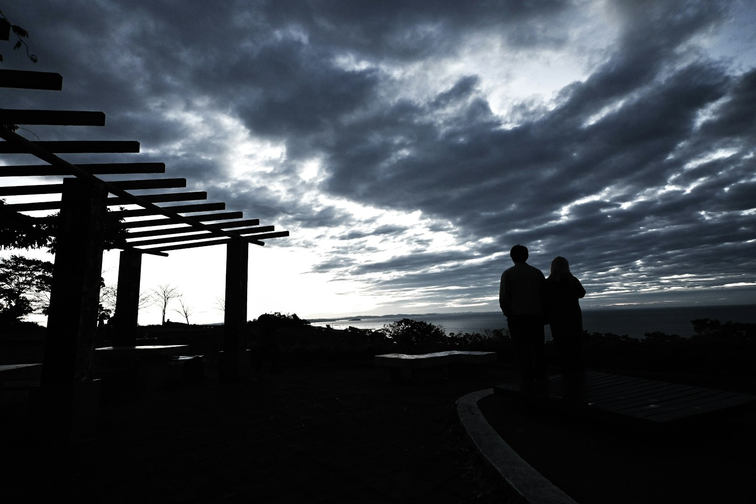 Silhouette di una coppia contro un cielo al crepuscolo con una pergola