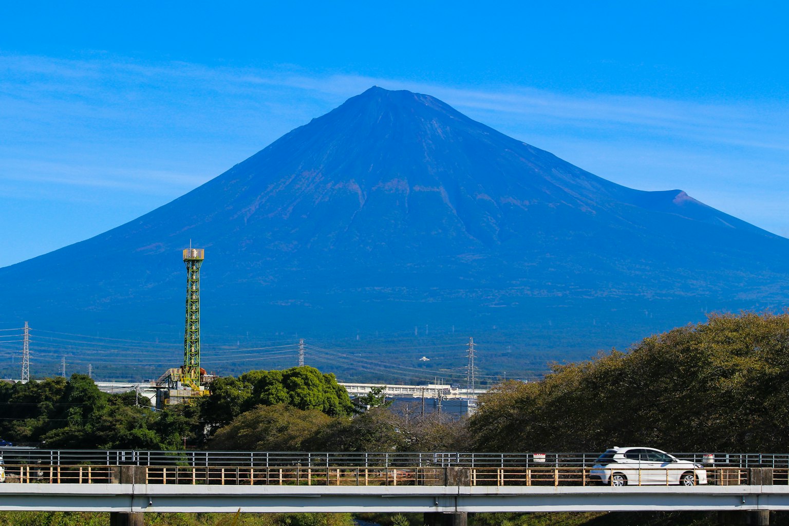 Landschaft des Fuji unter einem klaren blauen Himmel mit grünen Bäumen und einer Straße