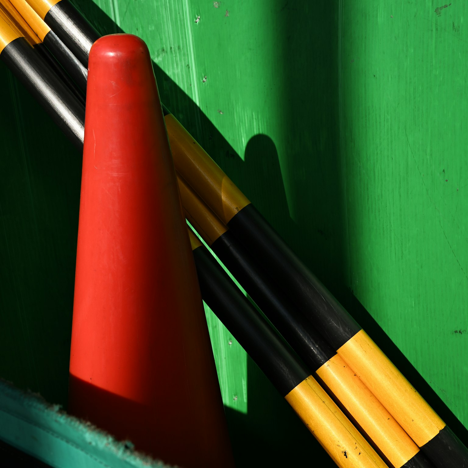 Cono rosso e pali neri e gialli su sfondo verde