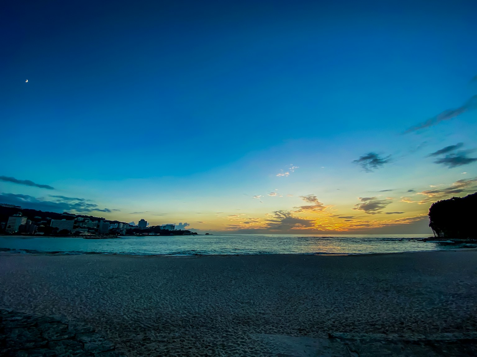 Magnifico paesaggio di spiaggia al tramonto con cielo blu e nuvole luna splendente