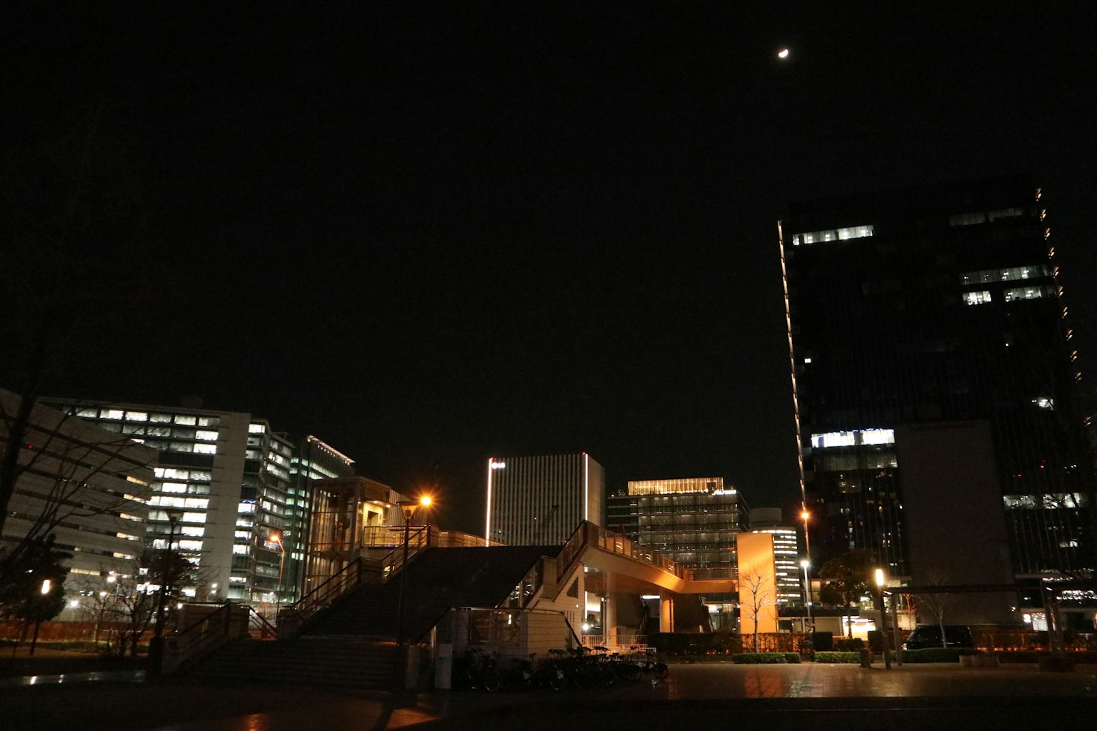Paesaggio urbano notturno con grattacieli illuminati e lampioni
