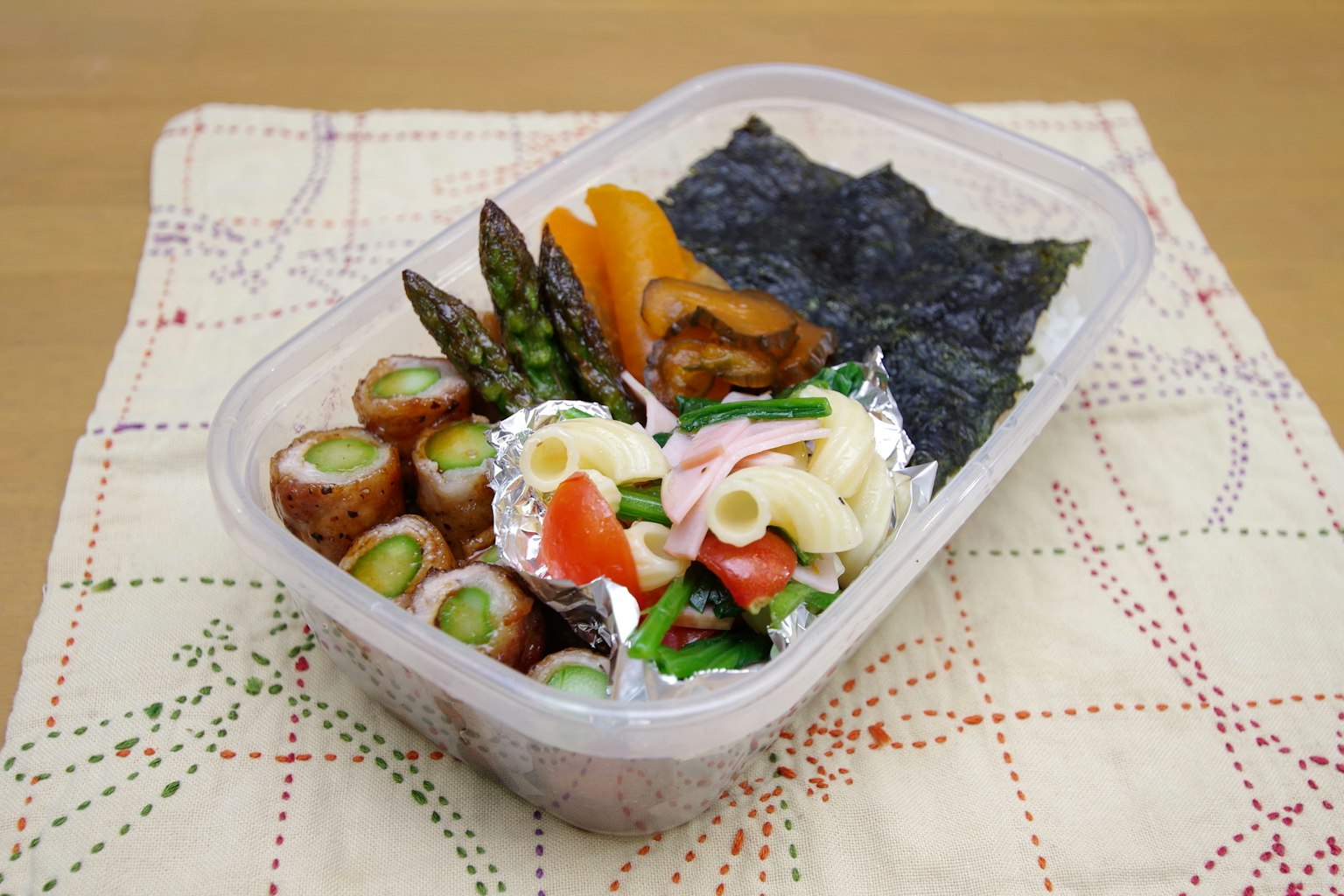 Hộp bento đầy màu sắc với nhiều nguyên liệu khác nhau bao gồm rong biển và măng tây