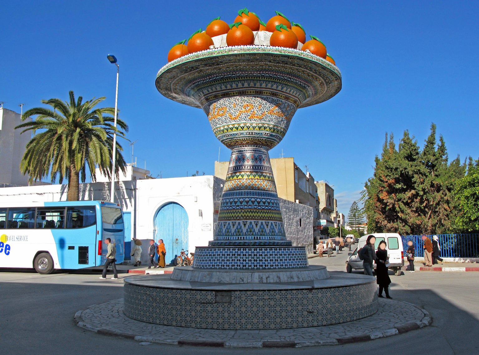 Fuente decorativa con naranjas vibrantes en una plaza pública
