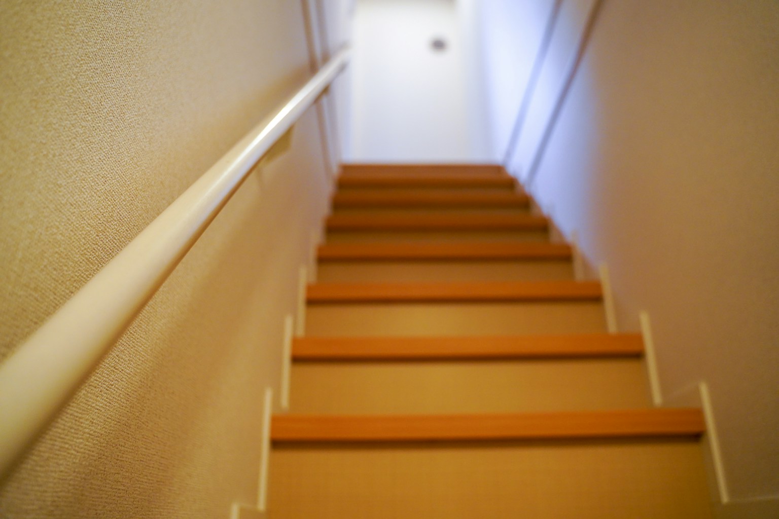 มุมมองของบันไดจากด้านล่างที่มีแสงสว่างสดใสและการออกแบบที่เรียบง่าย