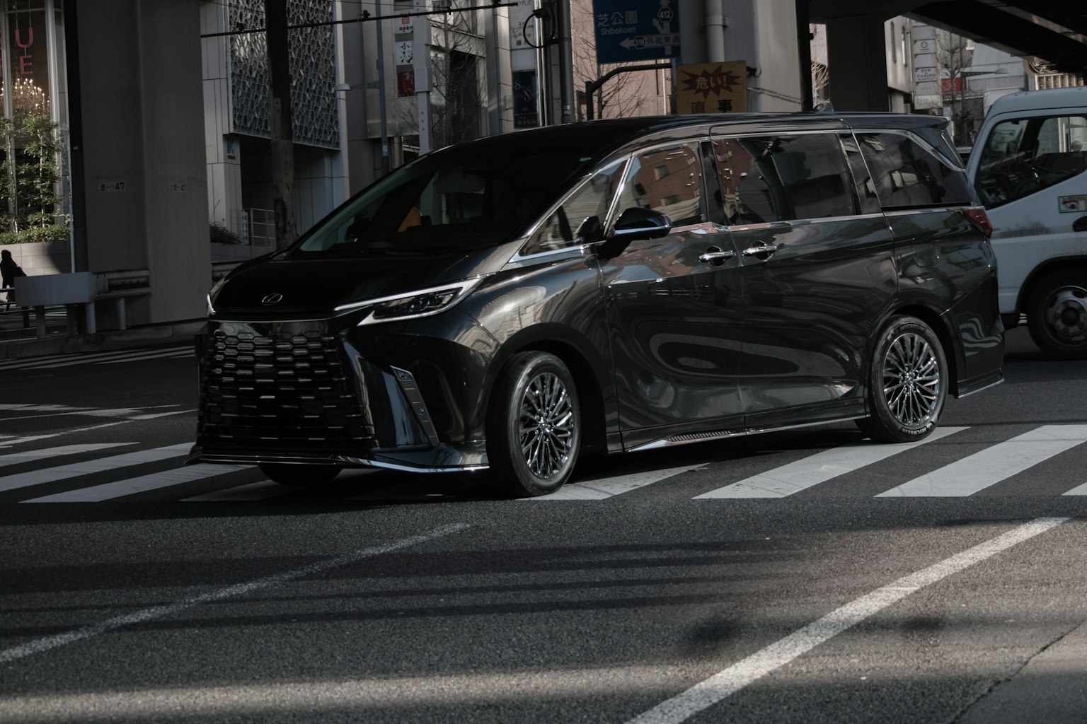 A black minivan crossing an intersection