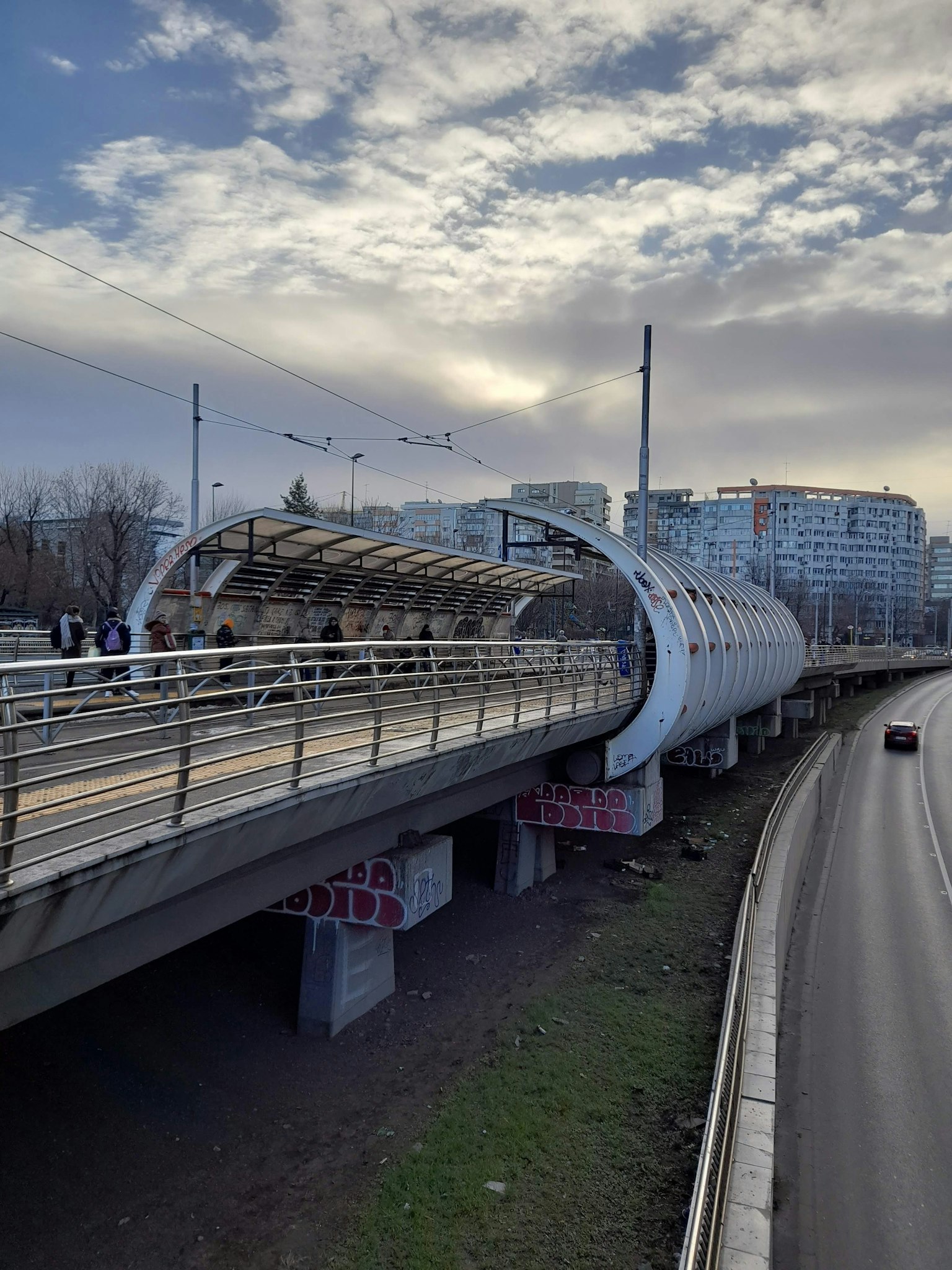 Un puente en arco blanco con un paisaje urbano al fondo