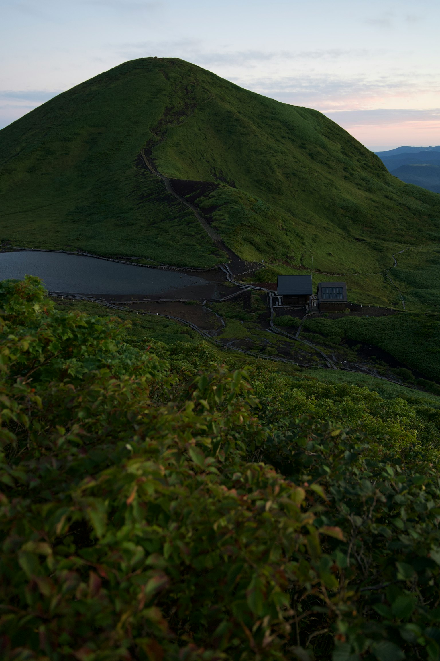 Vue panoramique d'une colline verte avec un petit étang