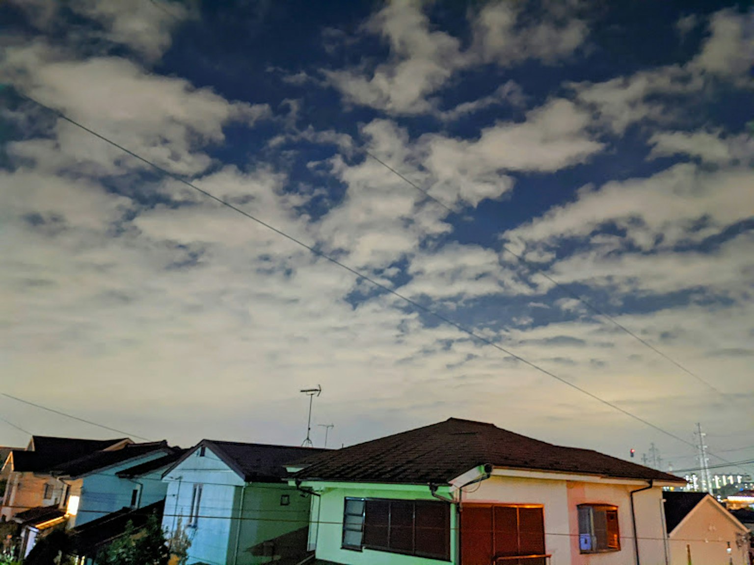 Cielo notturno con nuvole sopra case residenziali