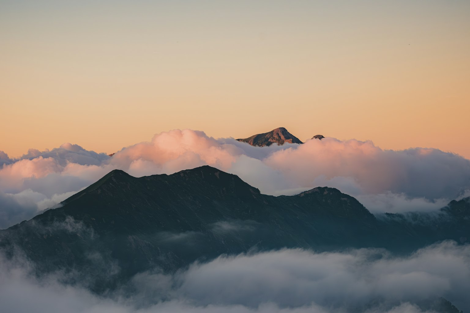 Vista escénica de montañas cubiertas de nubes al atardecer