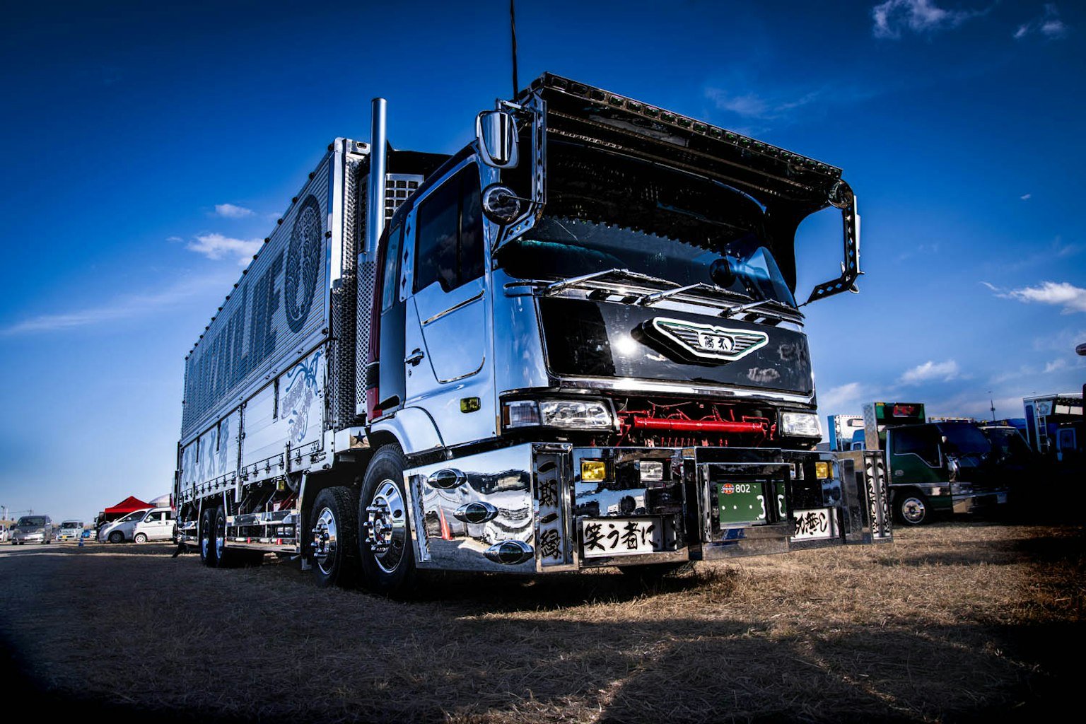 Ein glänzender silberner Lkw steht unter einem blauen Himmel