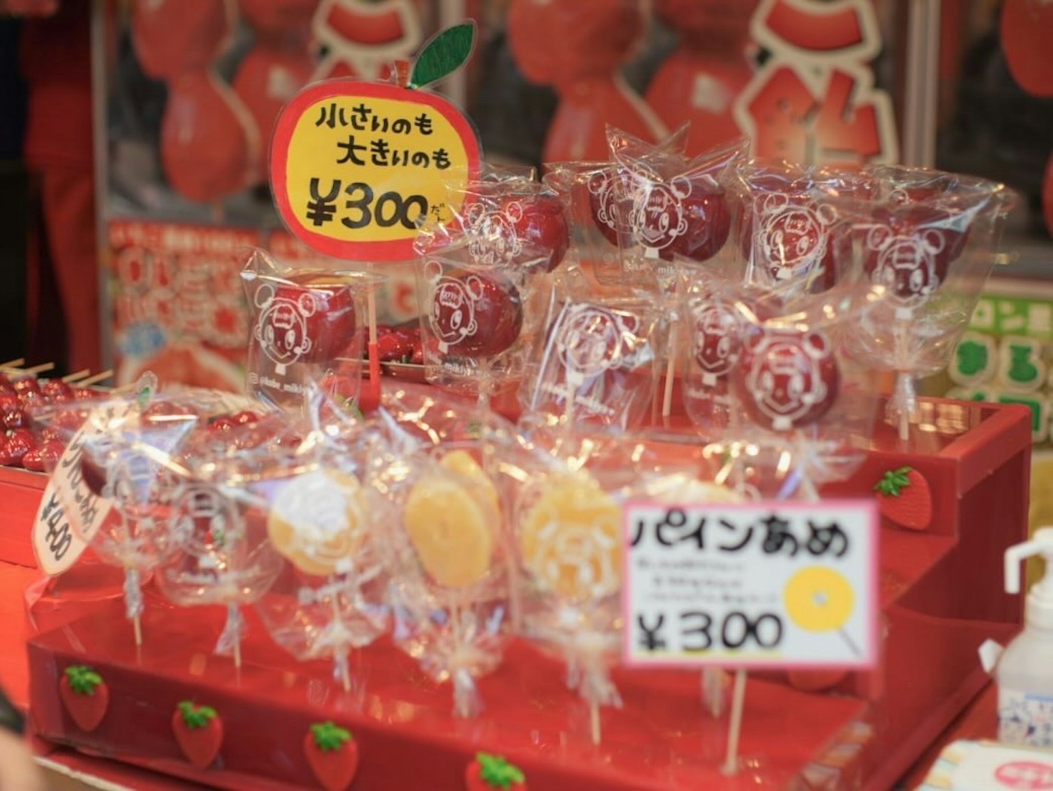 Display of red candy lollipops wrapped in ribbon on a snack shop counter