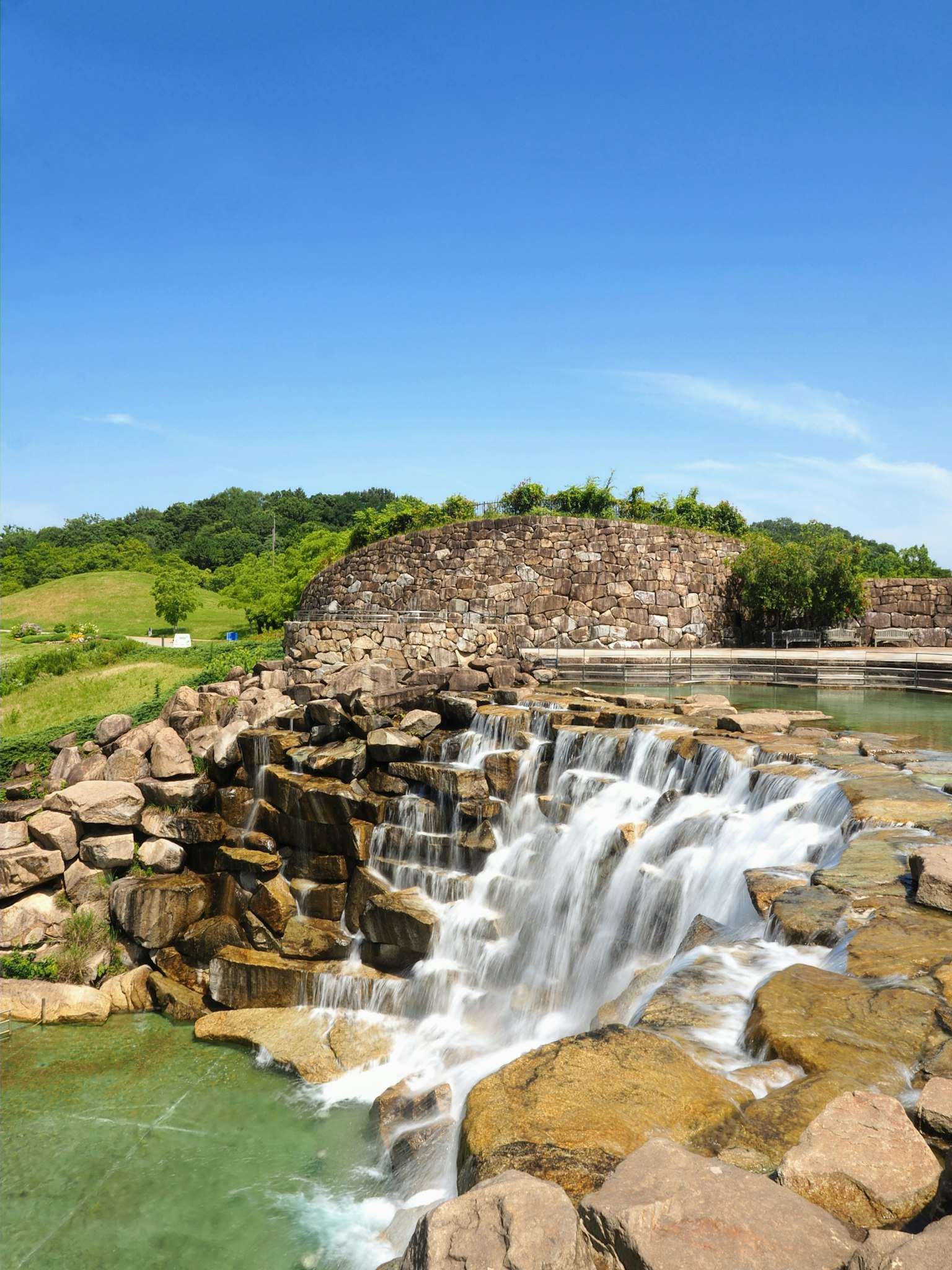 Bellissima cascata che scorre su rocce sotto un cielo blu chiaro