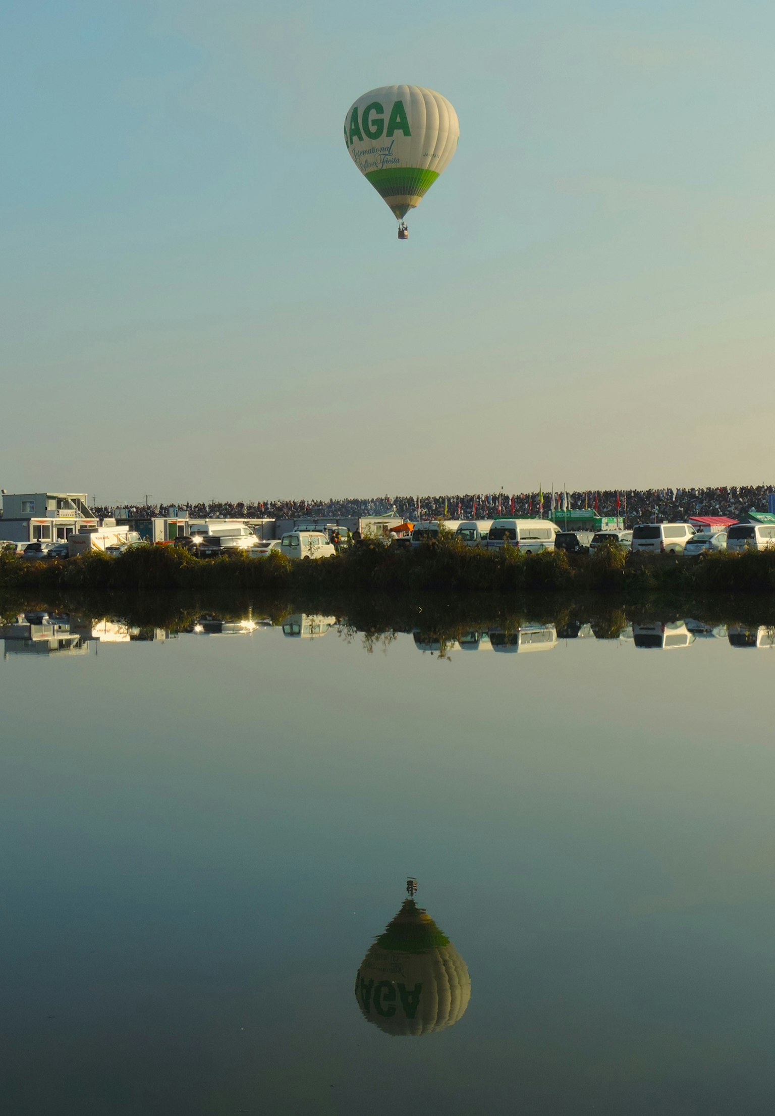 熱気球が湖の上空を飛んでいる風景の写真