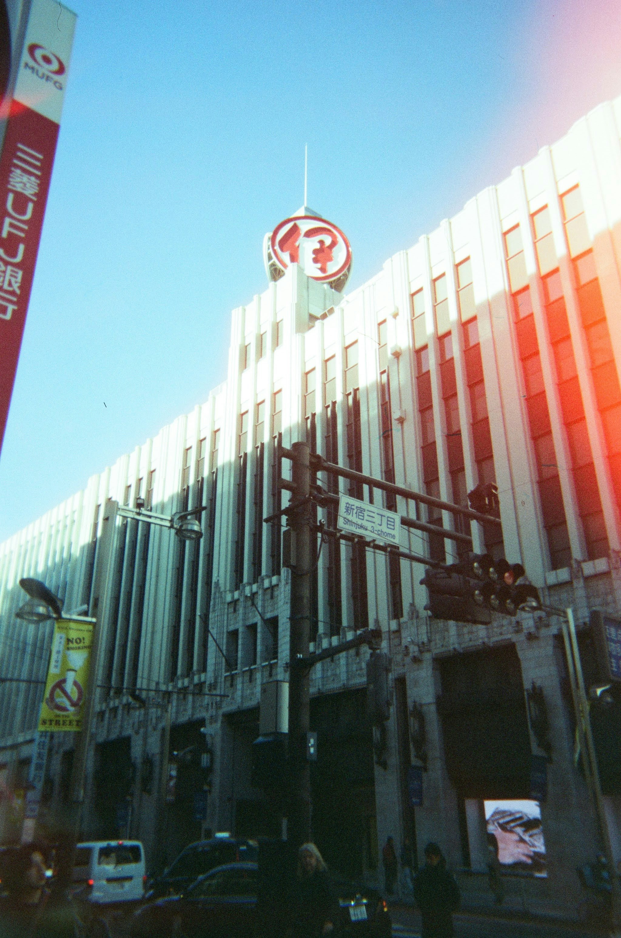 新宿の高層ビル街に掲げられた赤い看板と街のネオン感のある空