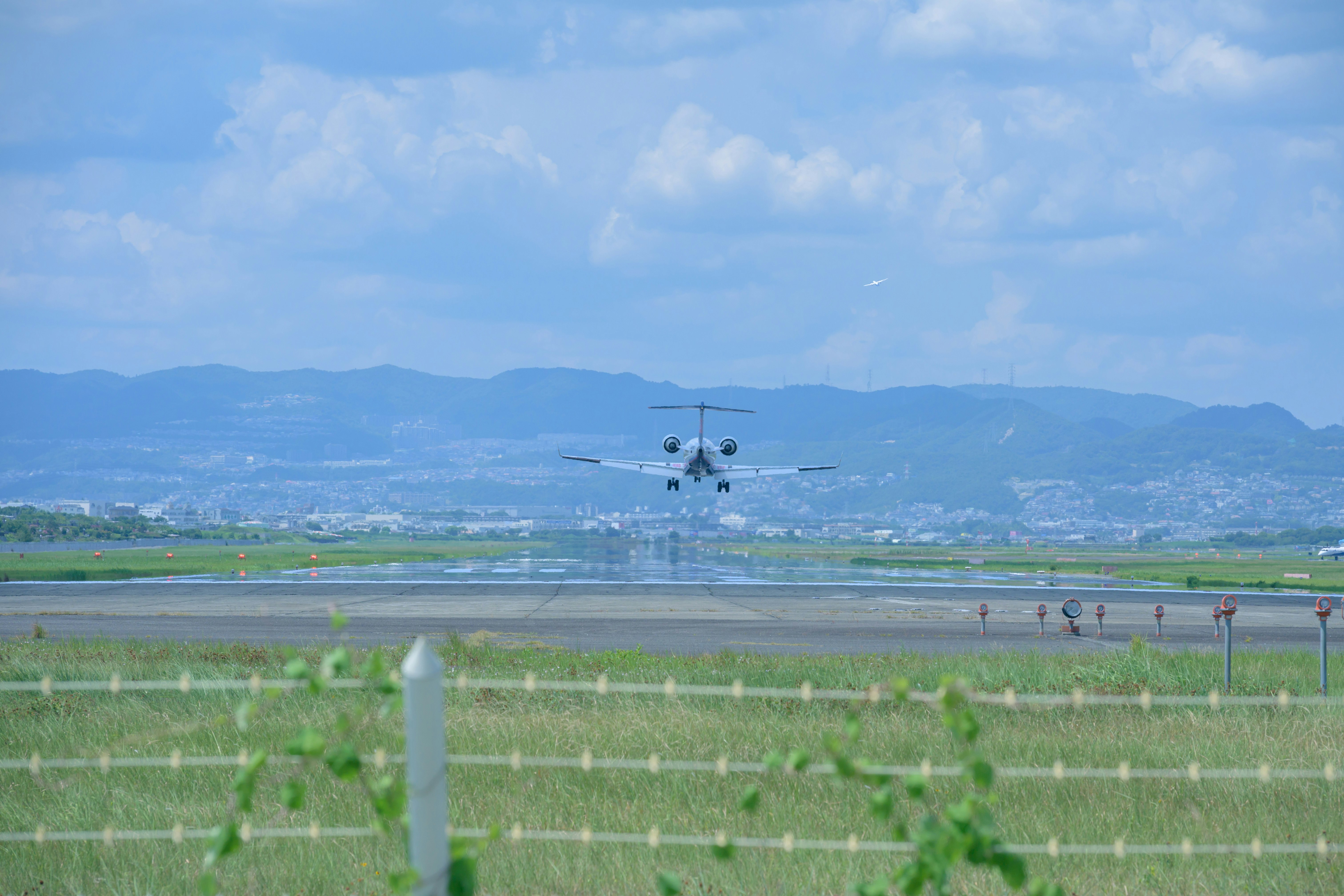 広い田園地帯の上空を飛ぶ旅客機のある風景