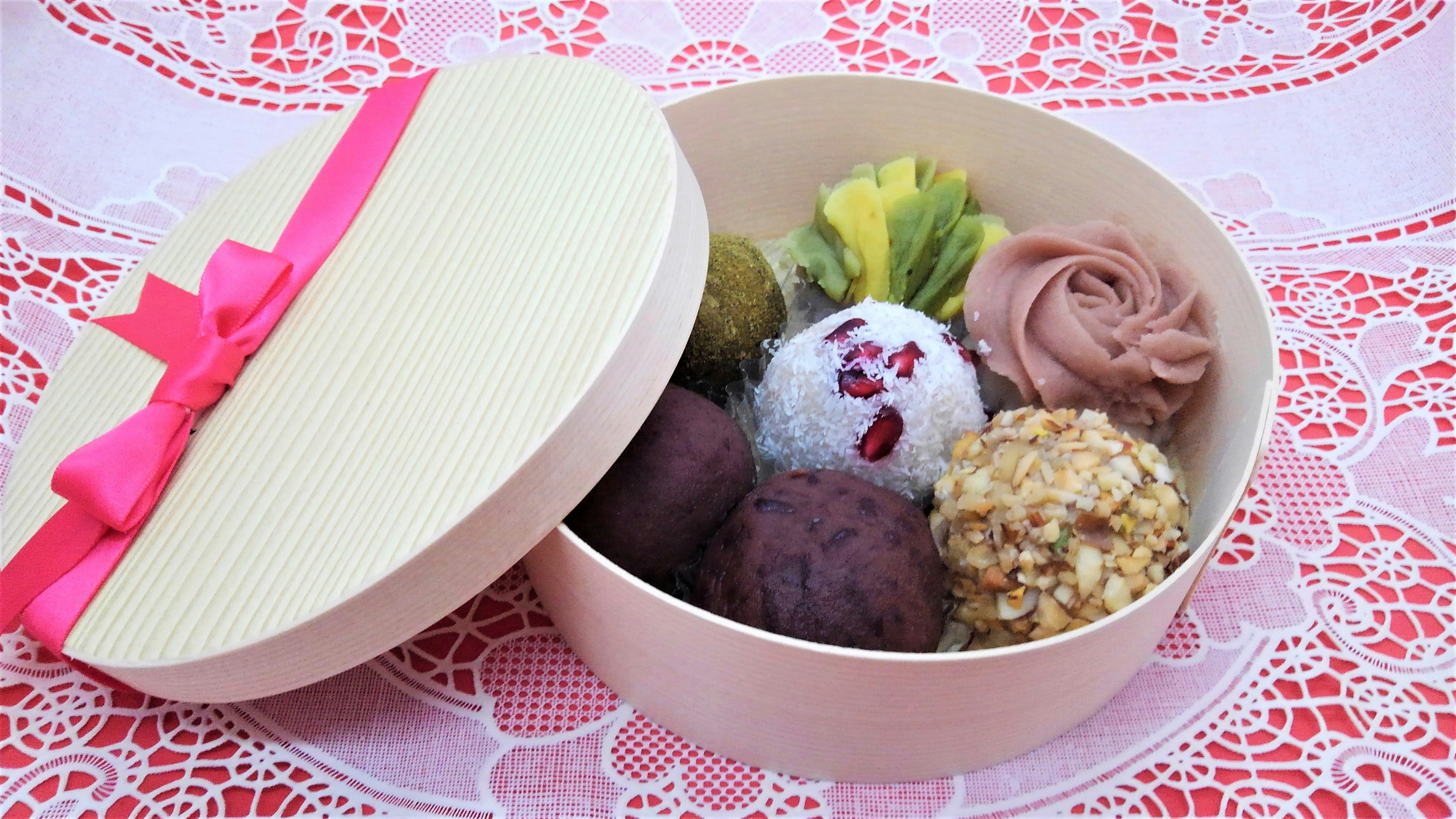 Süßigkeiten in einer hüteförmigen Geschenkbox mit rosa Schleife