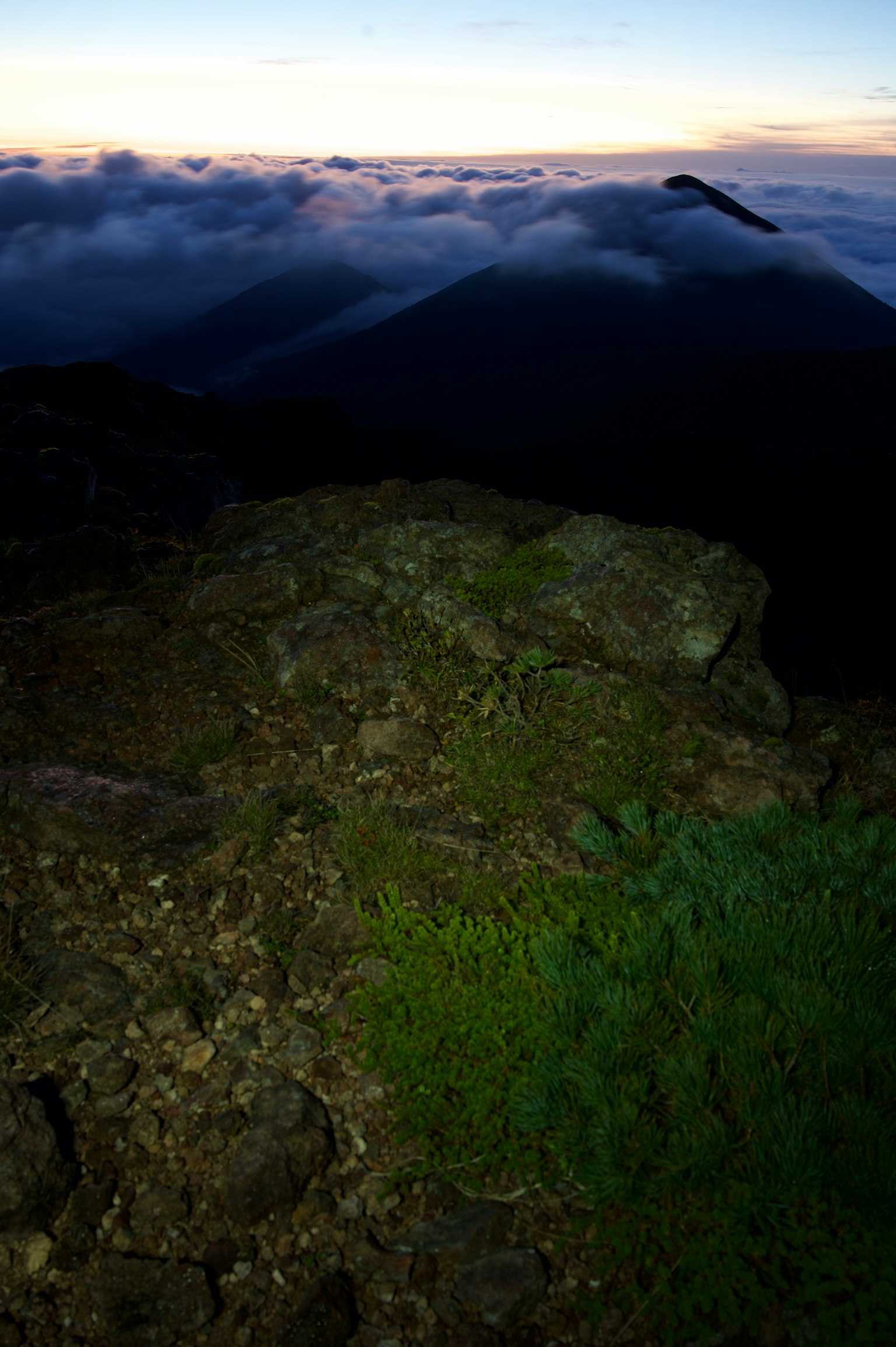 Rocky terrain with moss and clouds in the background at sunset