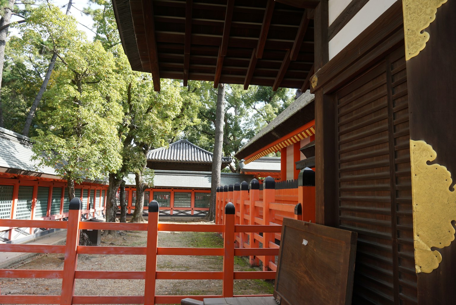 Vue d'un jardin avec une clôture rouge et des bâtiments traditionnels