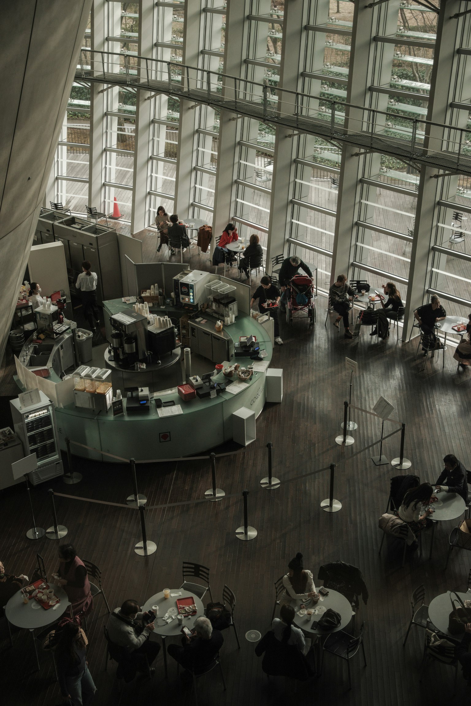 Innenansicht eines modernen Cafés mit Glaswänden und Menschen an Tischen