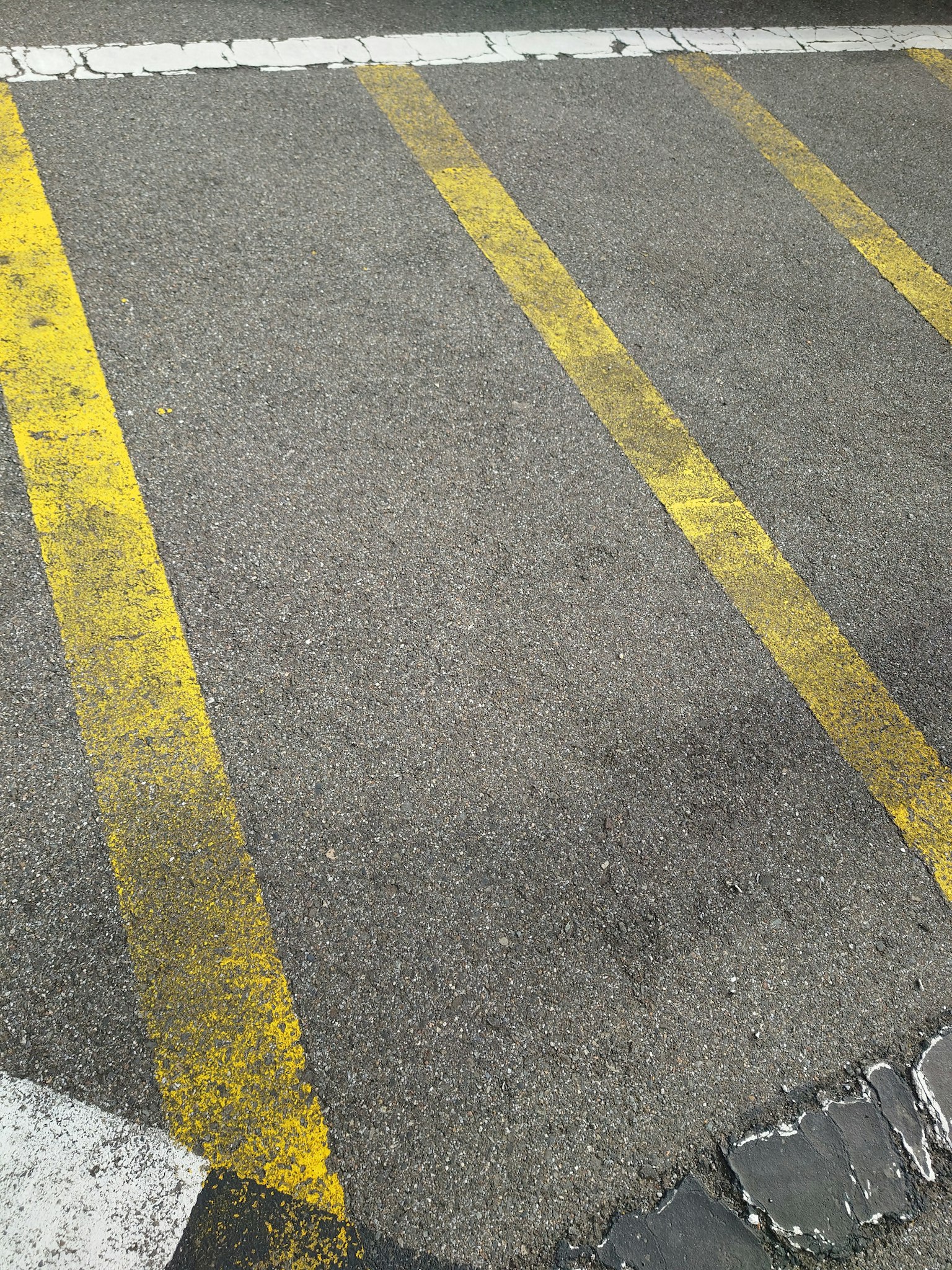 Partie d'une route en asphalte avec des lignes jaunes