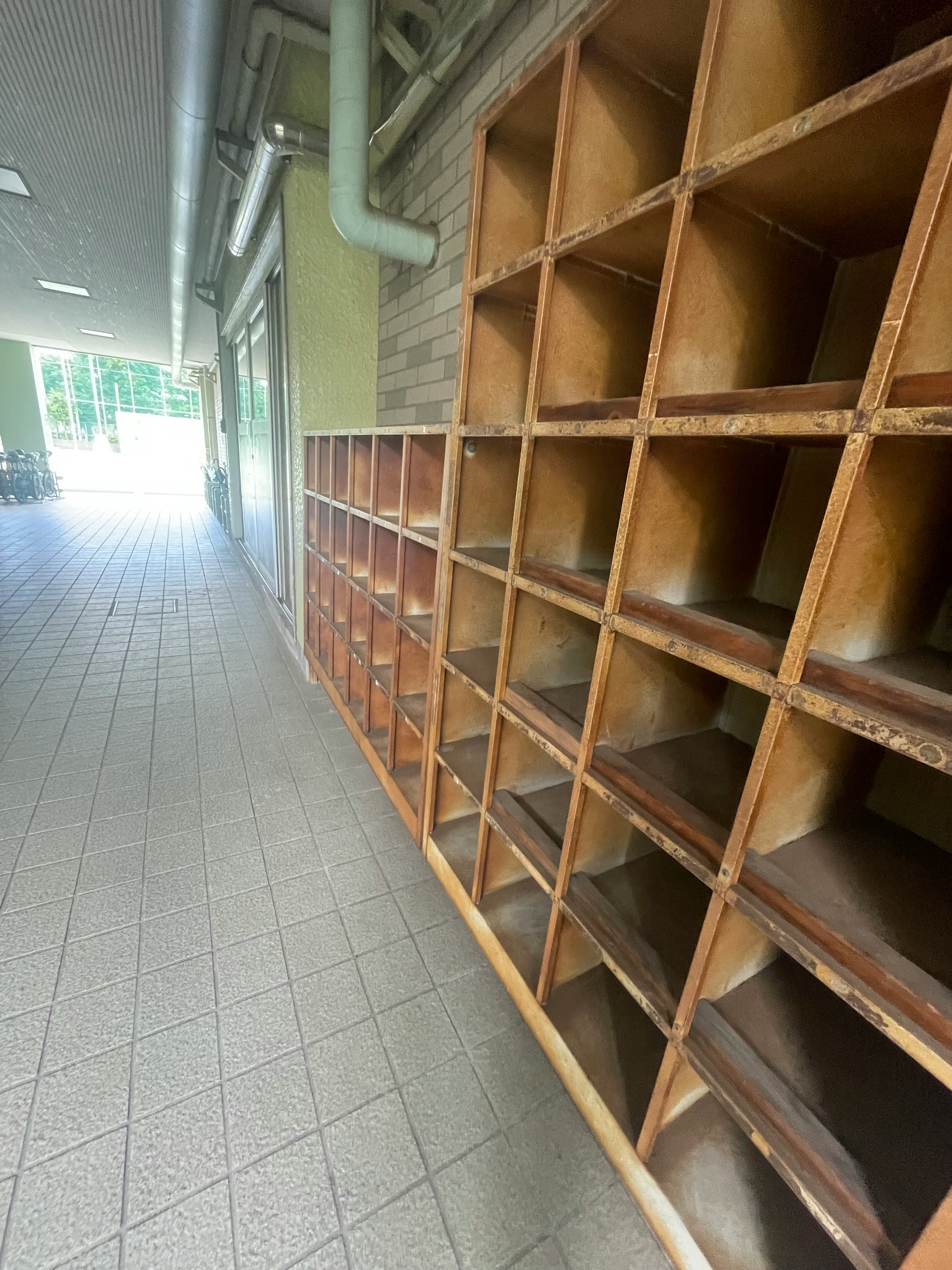 靴箱が並ぶ学校の廊下の棚