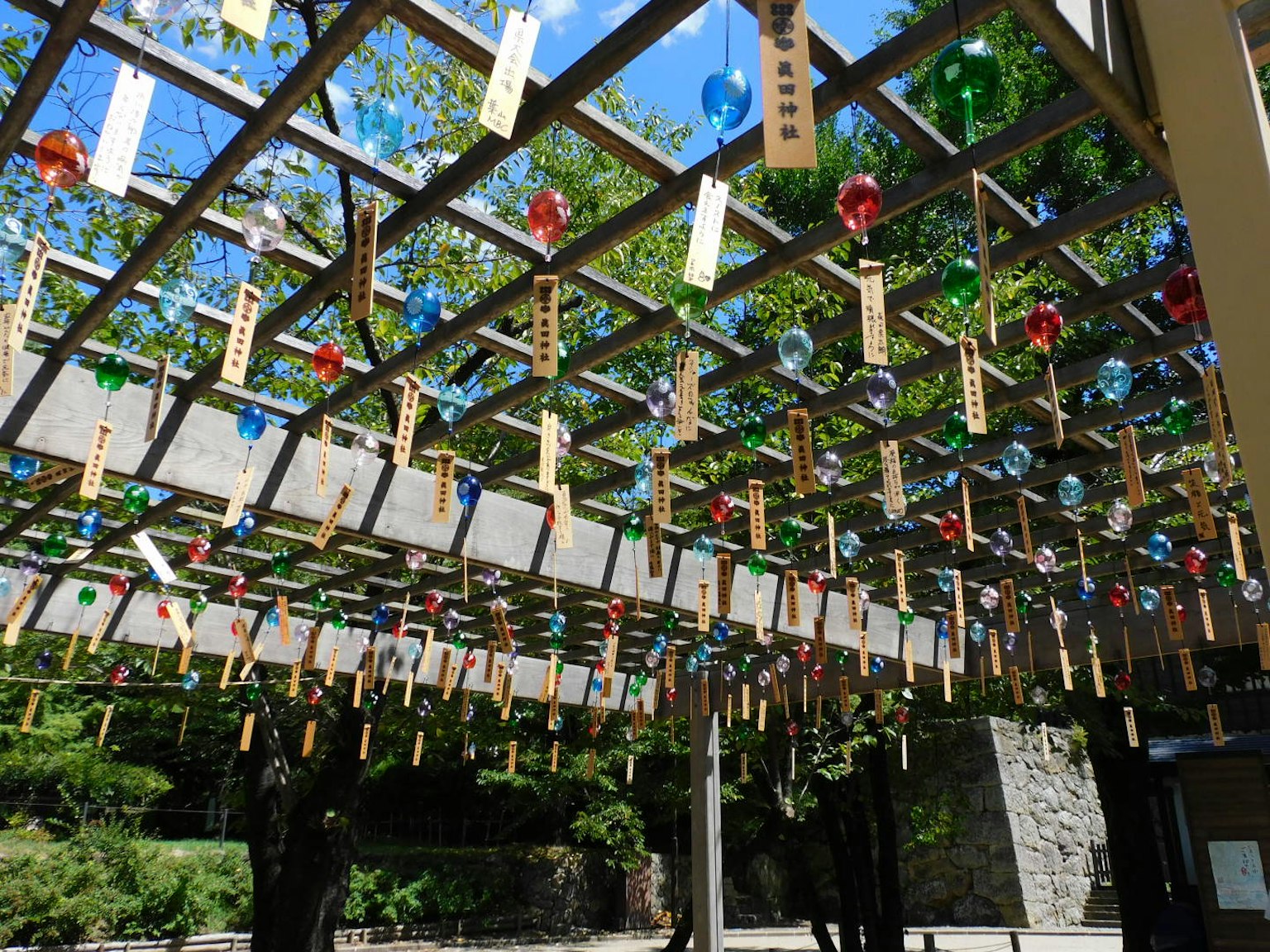Campanas de viento japonesas y tiras decorativas colgando bajo un cielo azul