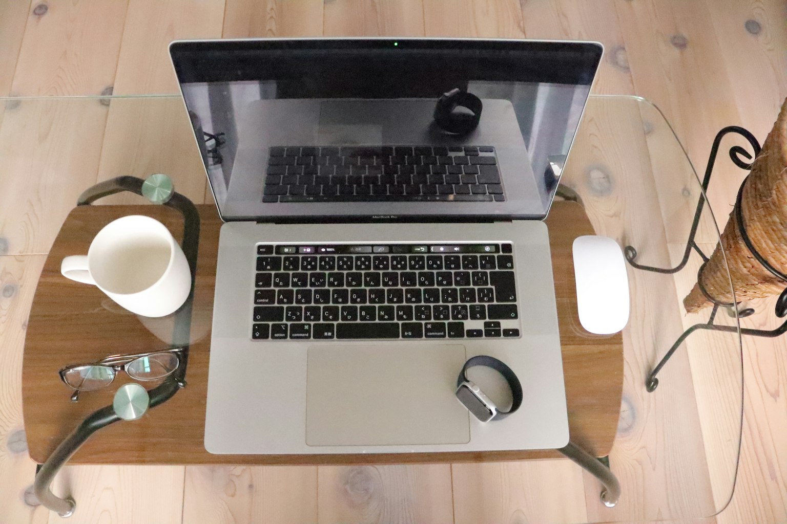 Laptop su un tavolo di legno con una tazza di caffè e occhiali