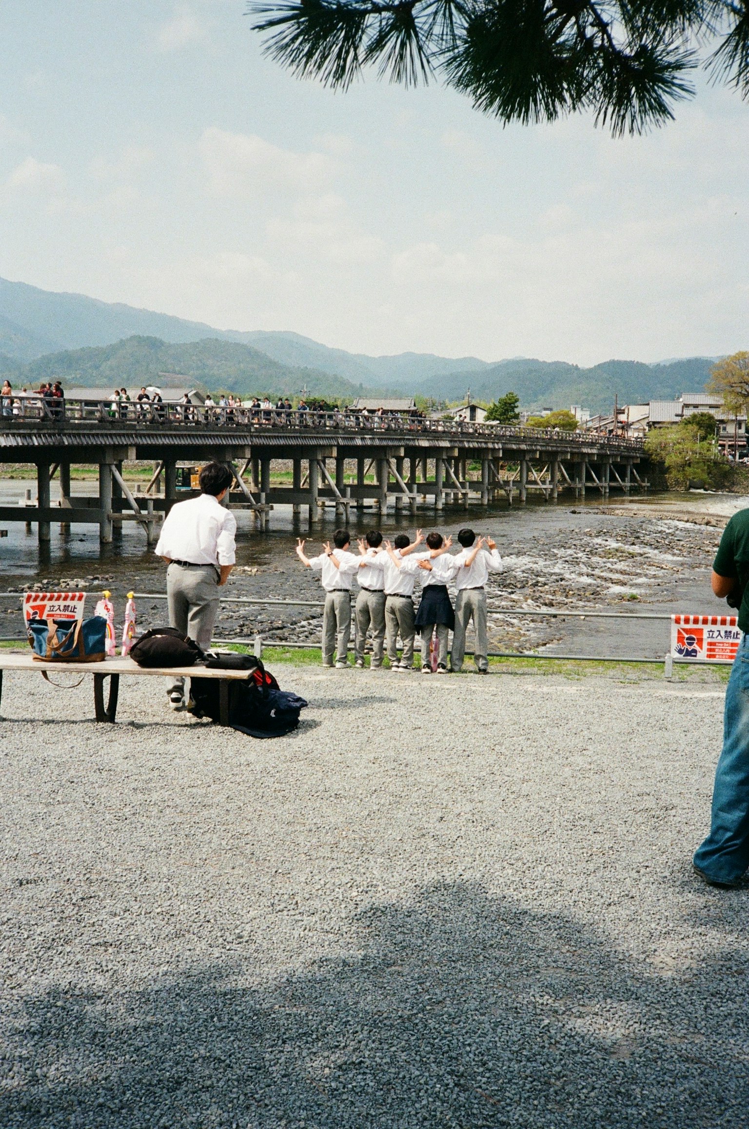 川の近くでポーズをとる人々と橋の風景