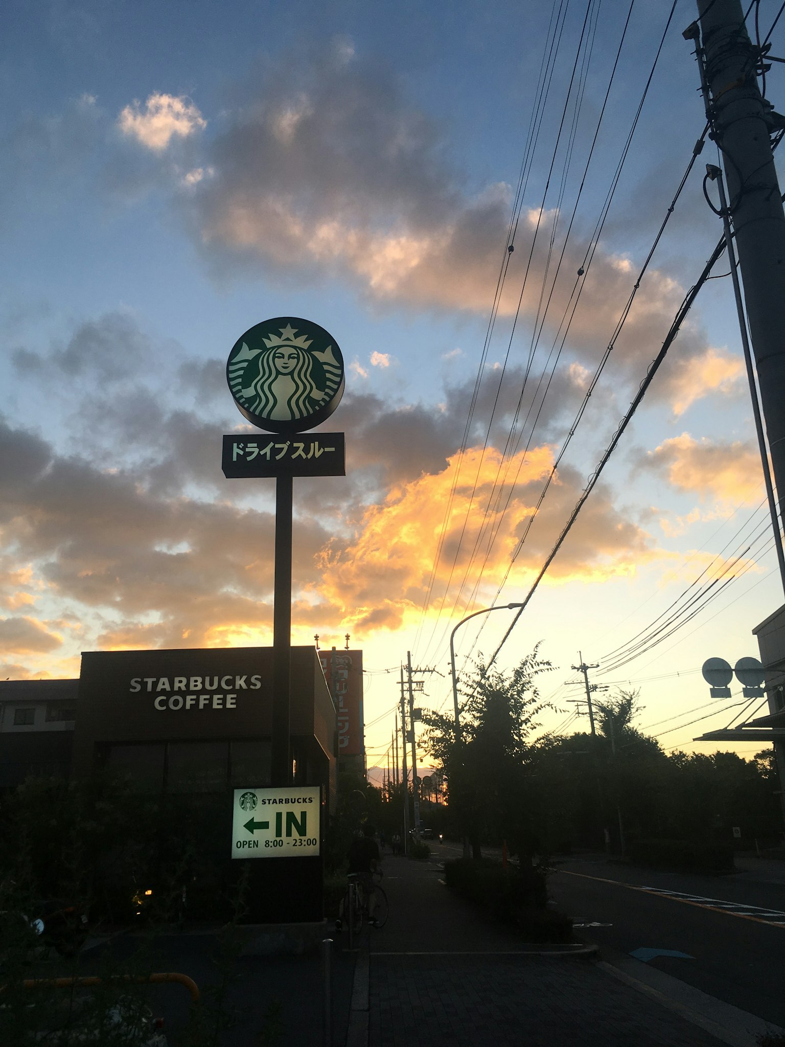 Biển hiệu Starbucks và quán cà phê dưới bầu trời hoàng hôn