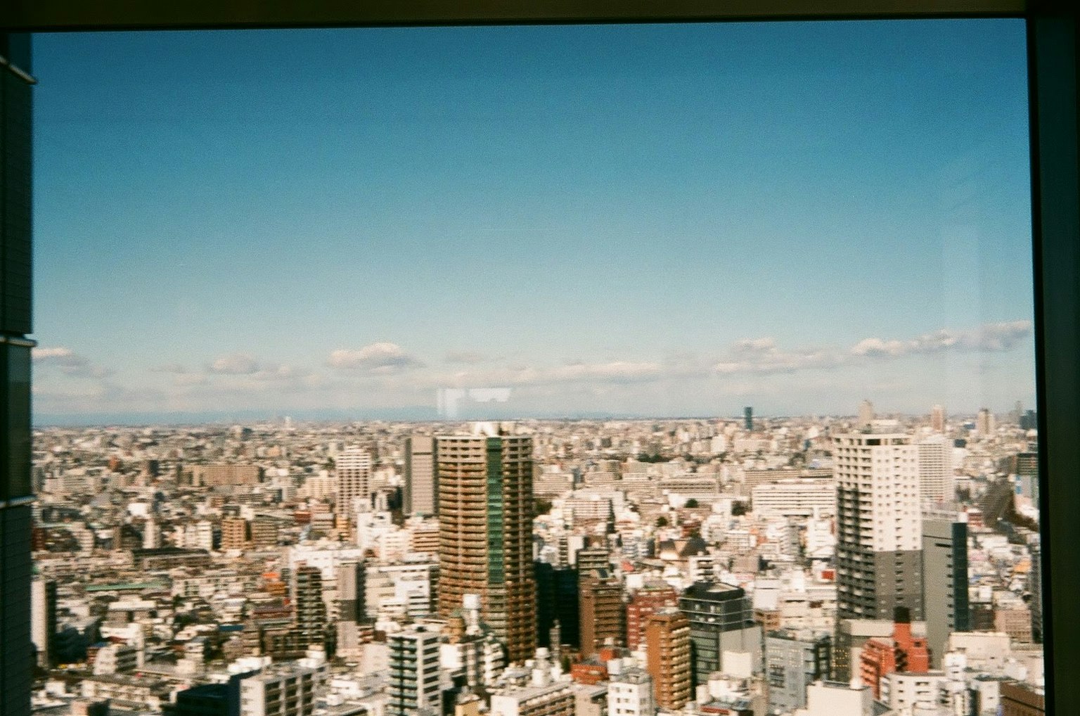 Panorama urbano con grattacieli sotto un cielo blu chiaro