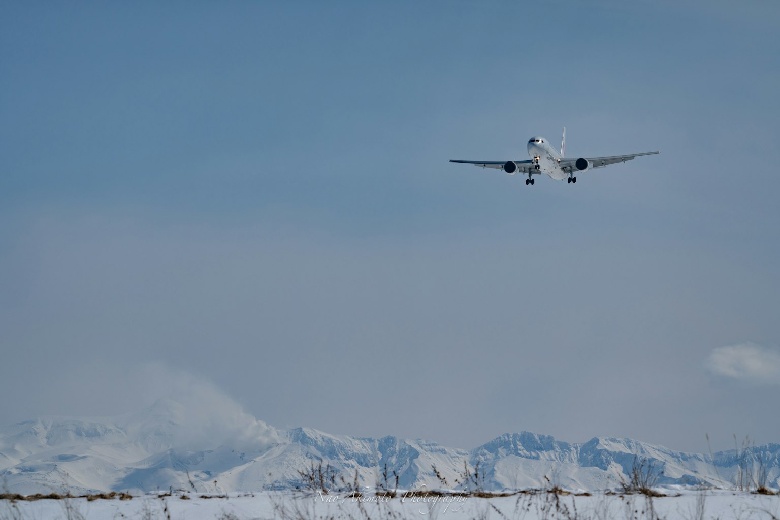 An airplane flying above snow-covered mountains
