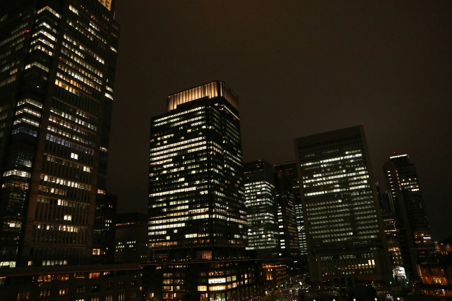 Rascacielos iluminados por la noche en un paisaje urbano