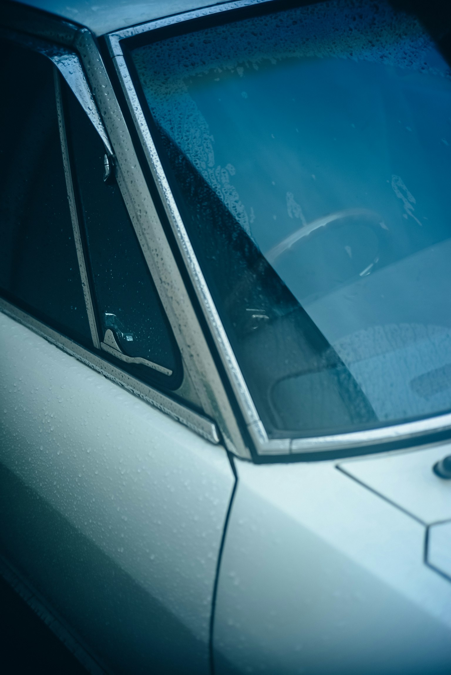 Primer plano de una ventana de coche azul y volante
