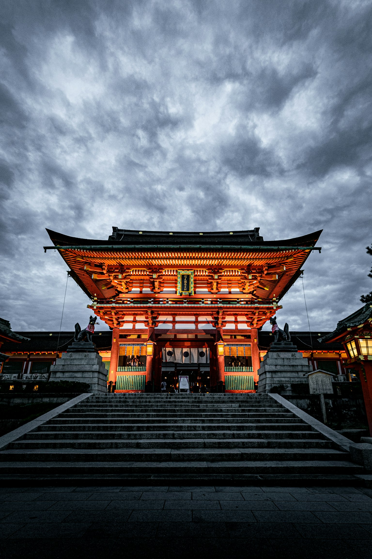 Temple with a red roof standing under dark clouds
