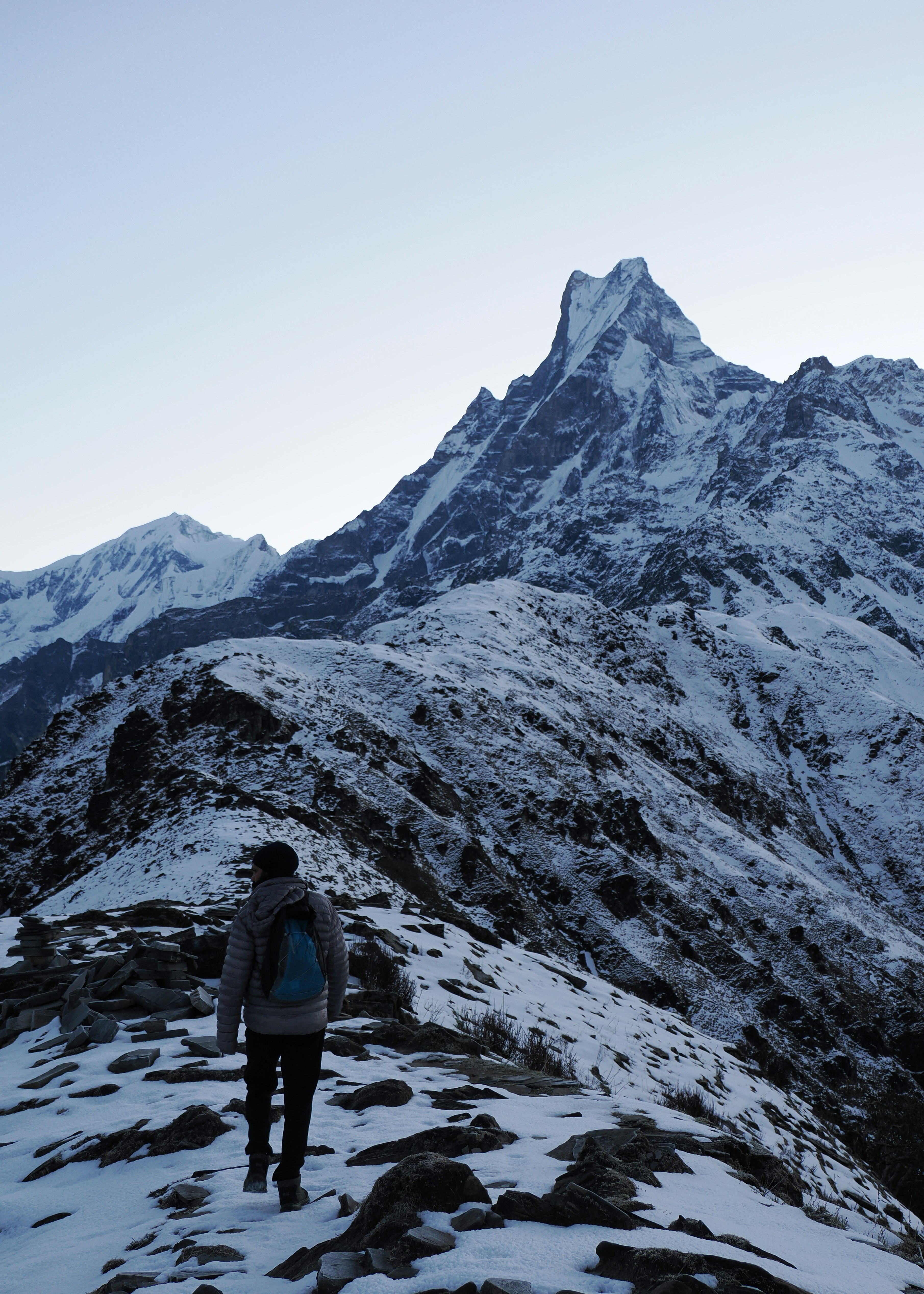 Un escursionista che guarda le cime innevate sotto un cielo sereno