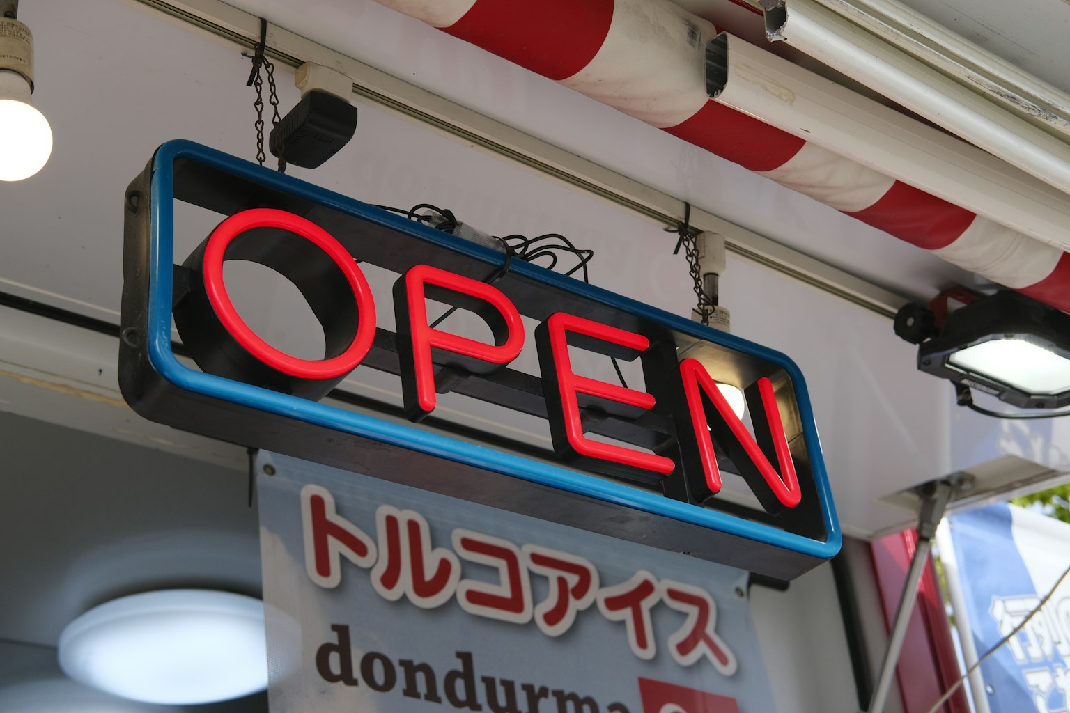 Helles rotes Neon-Schild 'OPEN' an der Vorderseite eines Geschäfts
