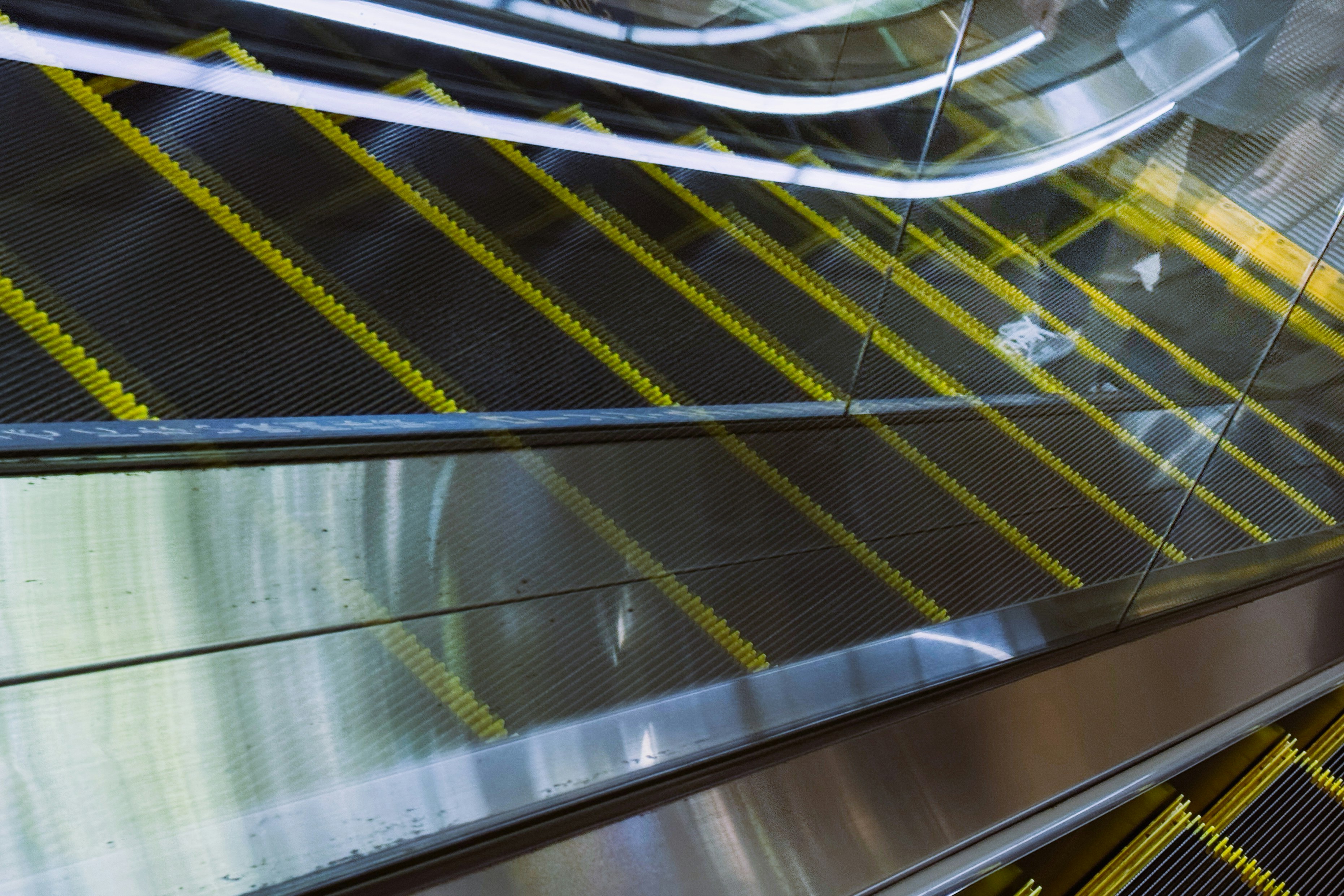bagian dalam moving walkway dengan rel logam dan garis kuning