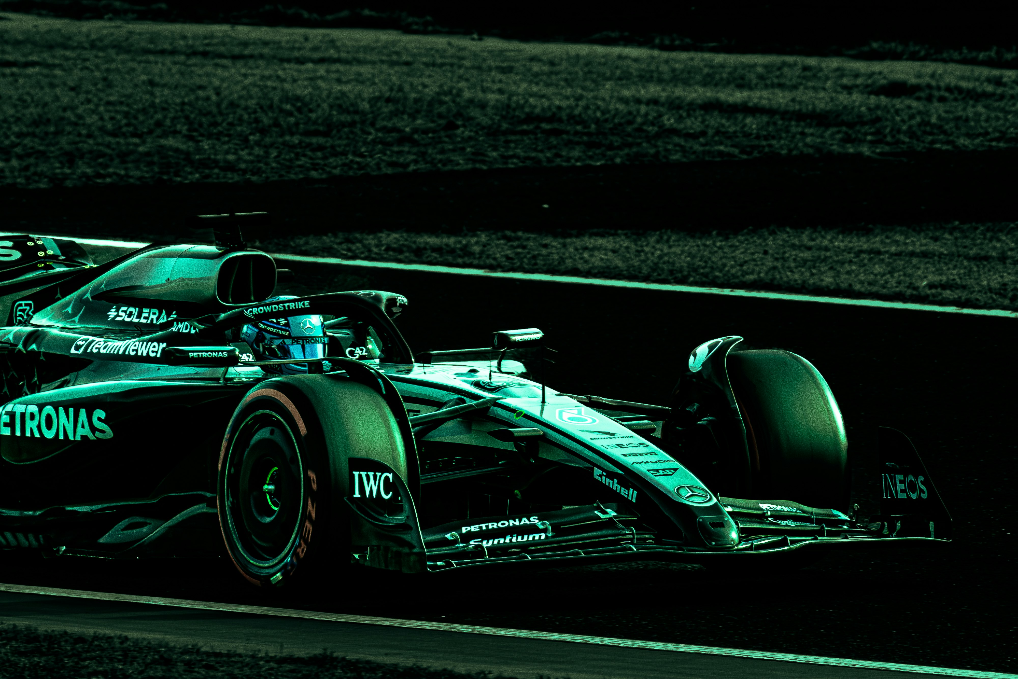 green Formula 1 car driving on a racetrack