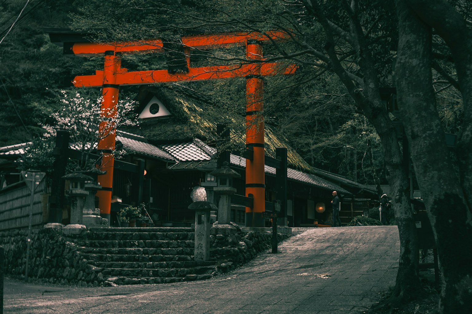 Eine ruhige Szene mit einem roten Torii und einem alten Gebäude