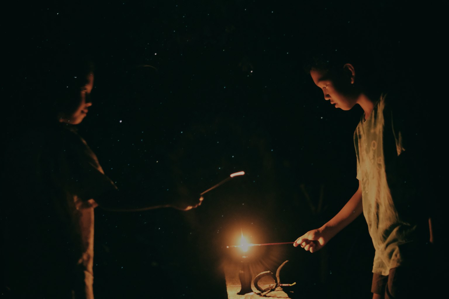 Two children creating sparks in the dark