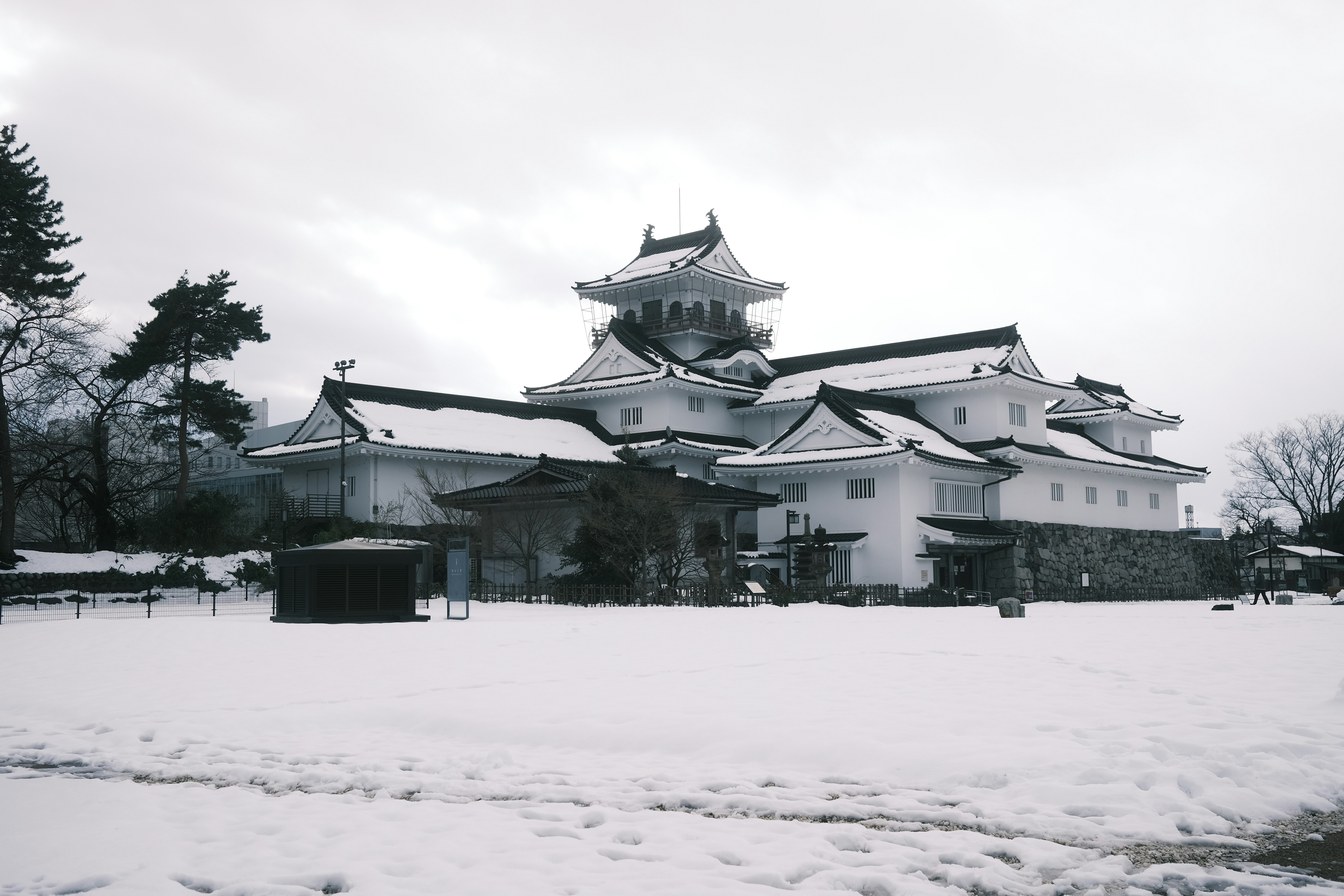 bâtiments blancs de style château couverts de neige et toits superposés
