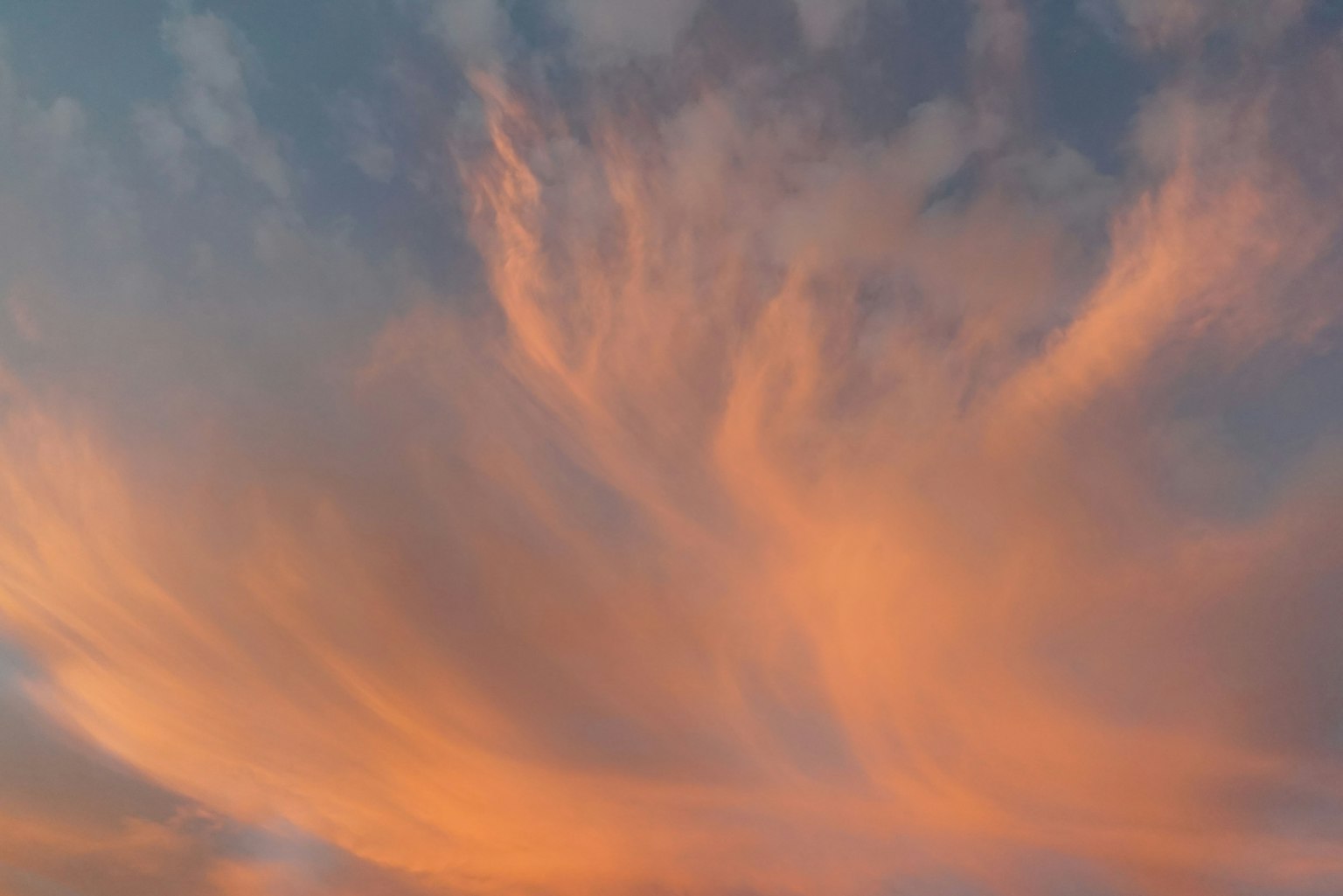 Sanfte orange Wolken breiten sich über den Himmel aus