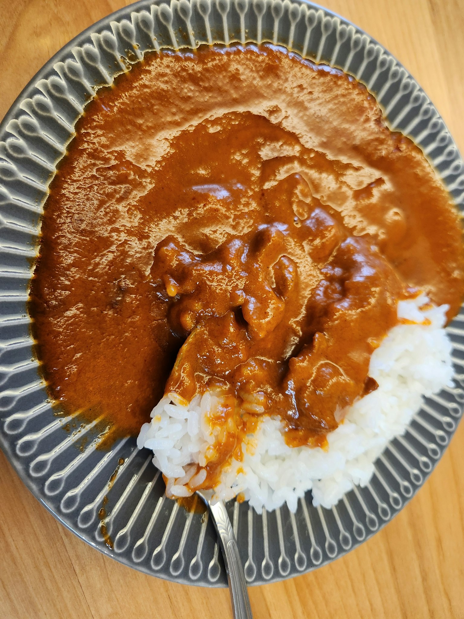 Hidangan nasi putih yang ditutupi saus kari