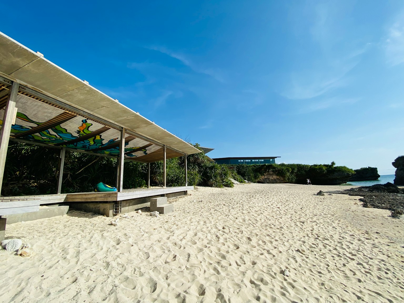 Paviliun pantai dengan pasir putih dan langit biru jernih
