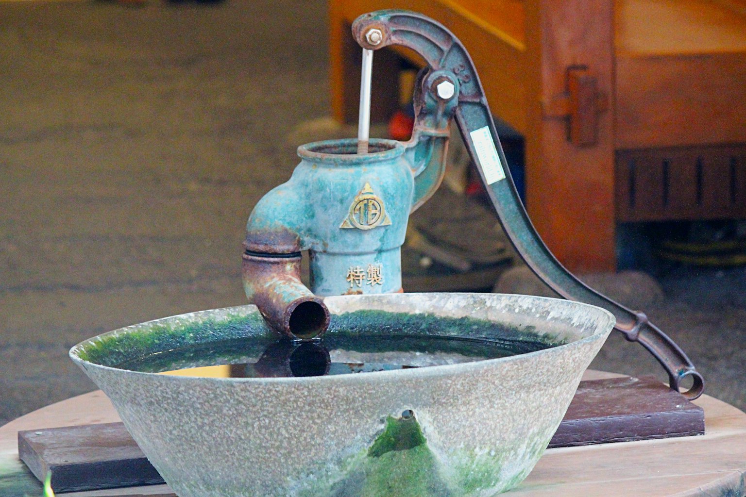 Image d'une pompe à eau bleue et d'un grand bassin rempli d'eau