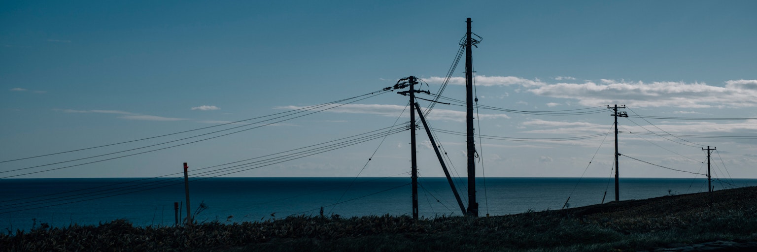 Coastal view with power poles and blue sky