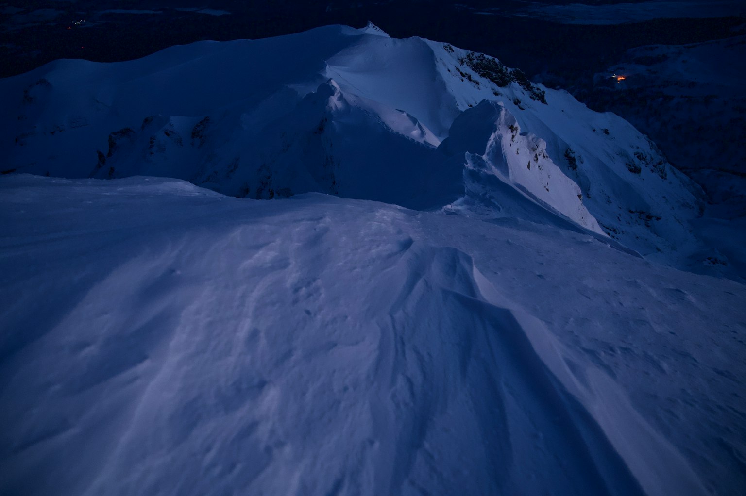被微光照亮的雪覆蓋山坡
